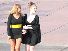 Two horny girls in black dresses lick each others big boobs